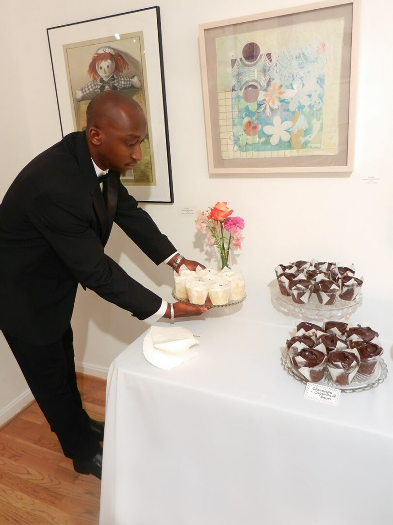 A Man in a Suit Arranging Food on a Table