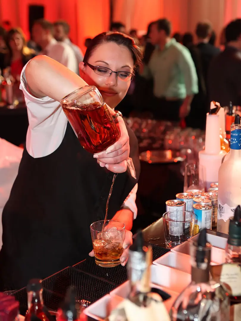 A Woman Mixing Cocktail Drinks at a Party